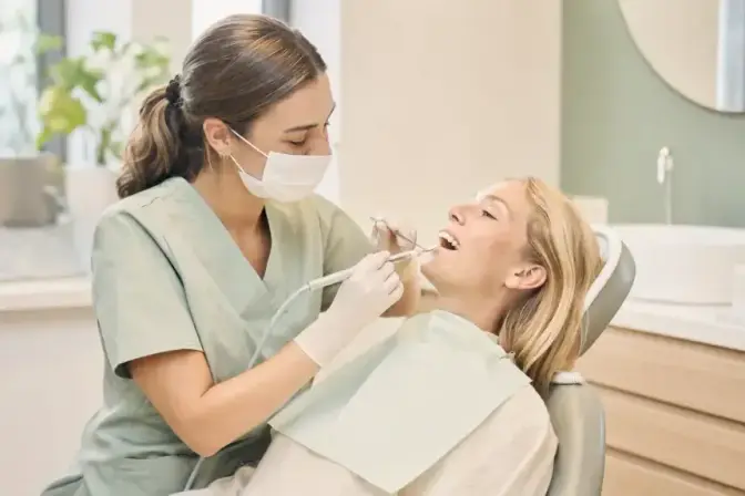 Mondhygiënist reinigt het gebit van een patiënt en verwijdert tandsteen.